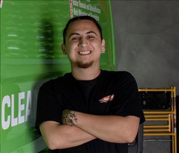 Male employee in front of SERVPRO vehicle.