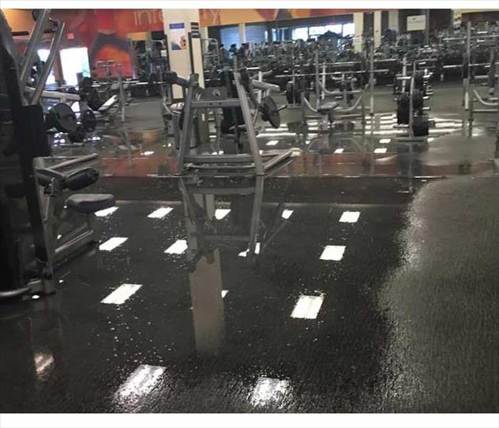 pooling water reflecting ceiling lights with gym equipment