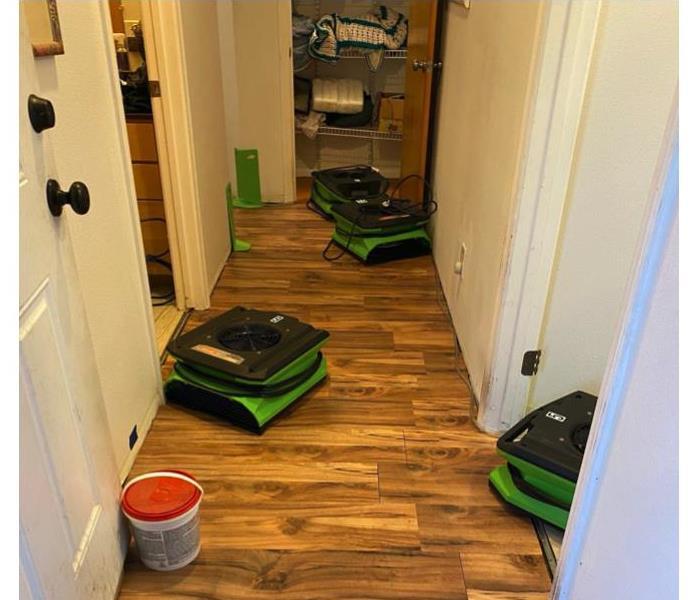 Four SERVPRO air movers in hallway of home.